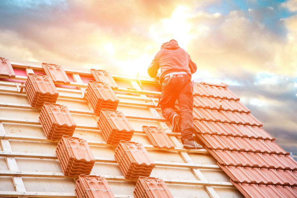 Roofer working on roof structure of building on construction site