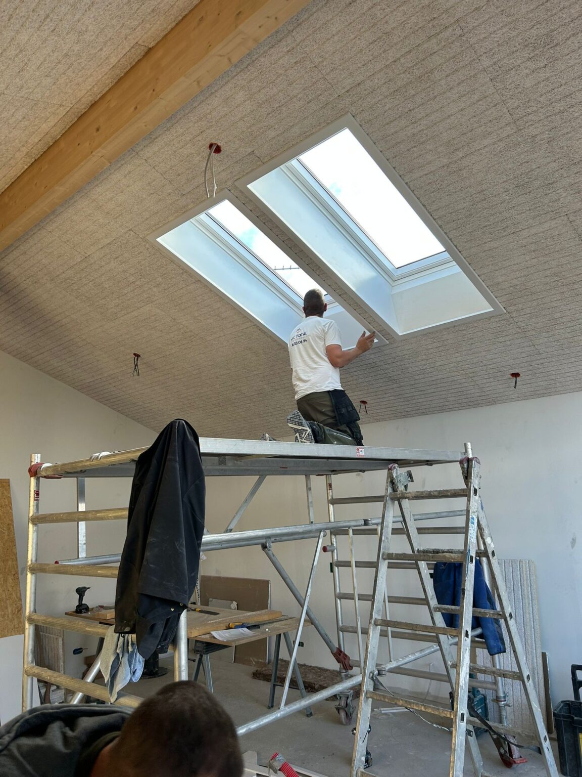 Håndværker monterer ovenlysvinduer i nyt loft